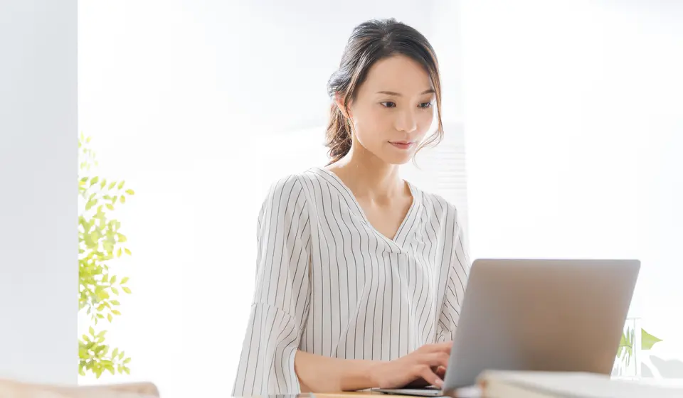 自宅でパソコンを使って働く女性
